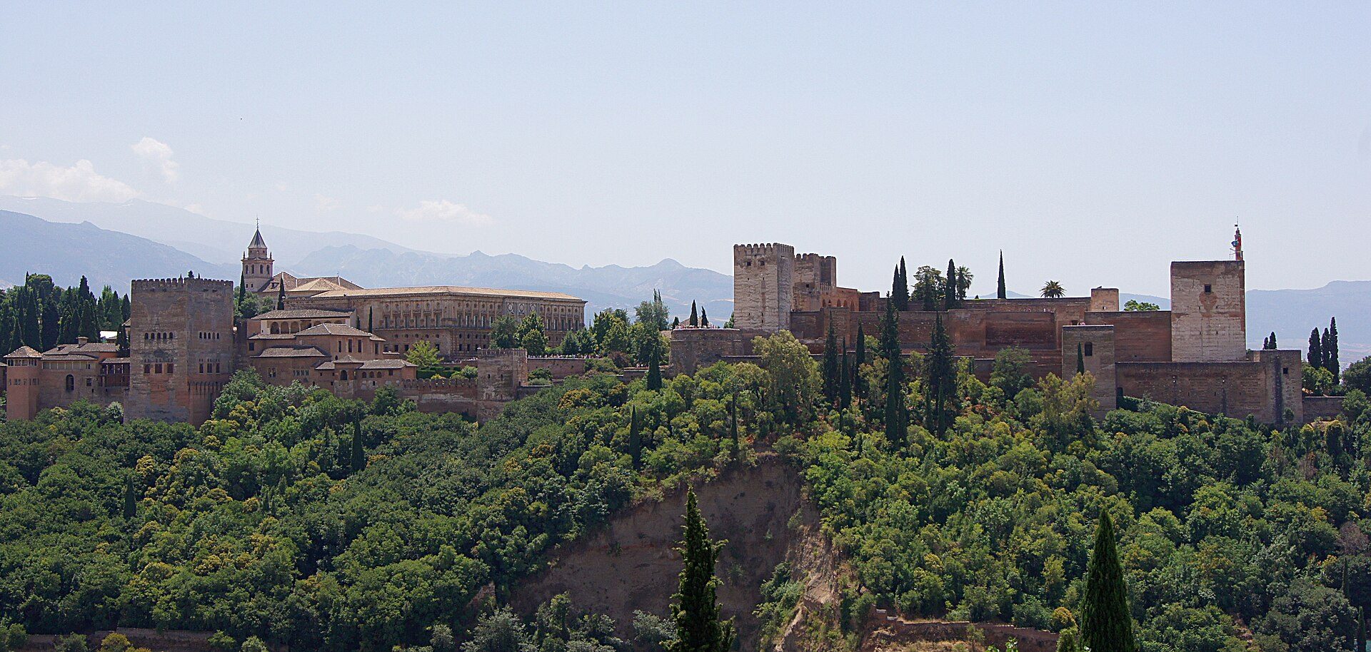 Vista exterior de la Alhambra y su bosque, con Sierra Nevada al fondo
