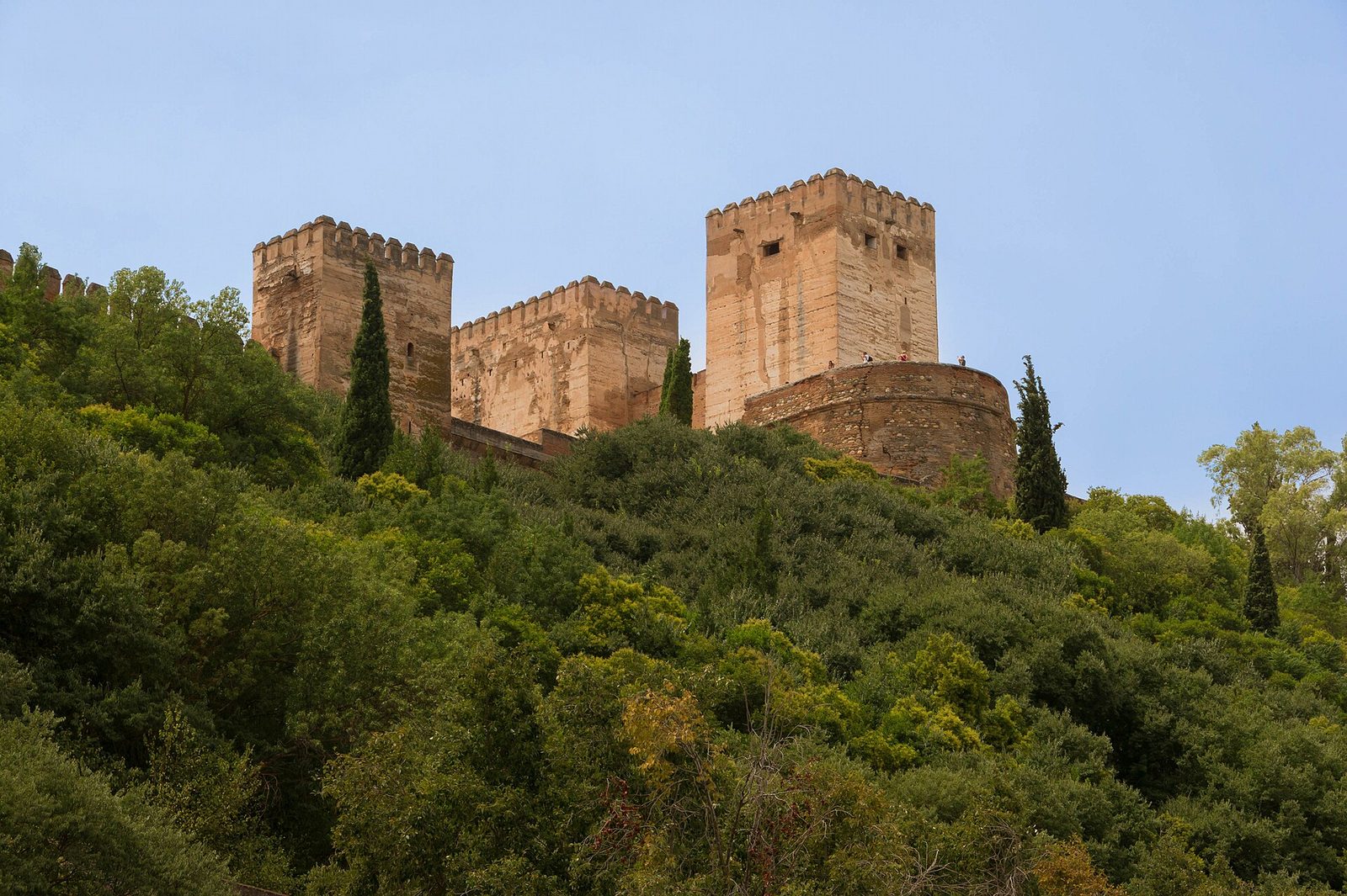 Murallas y torres exteriores de la Alhambra entre el arbolado