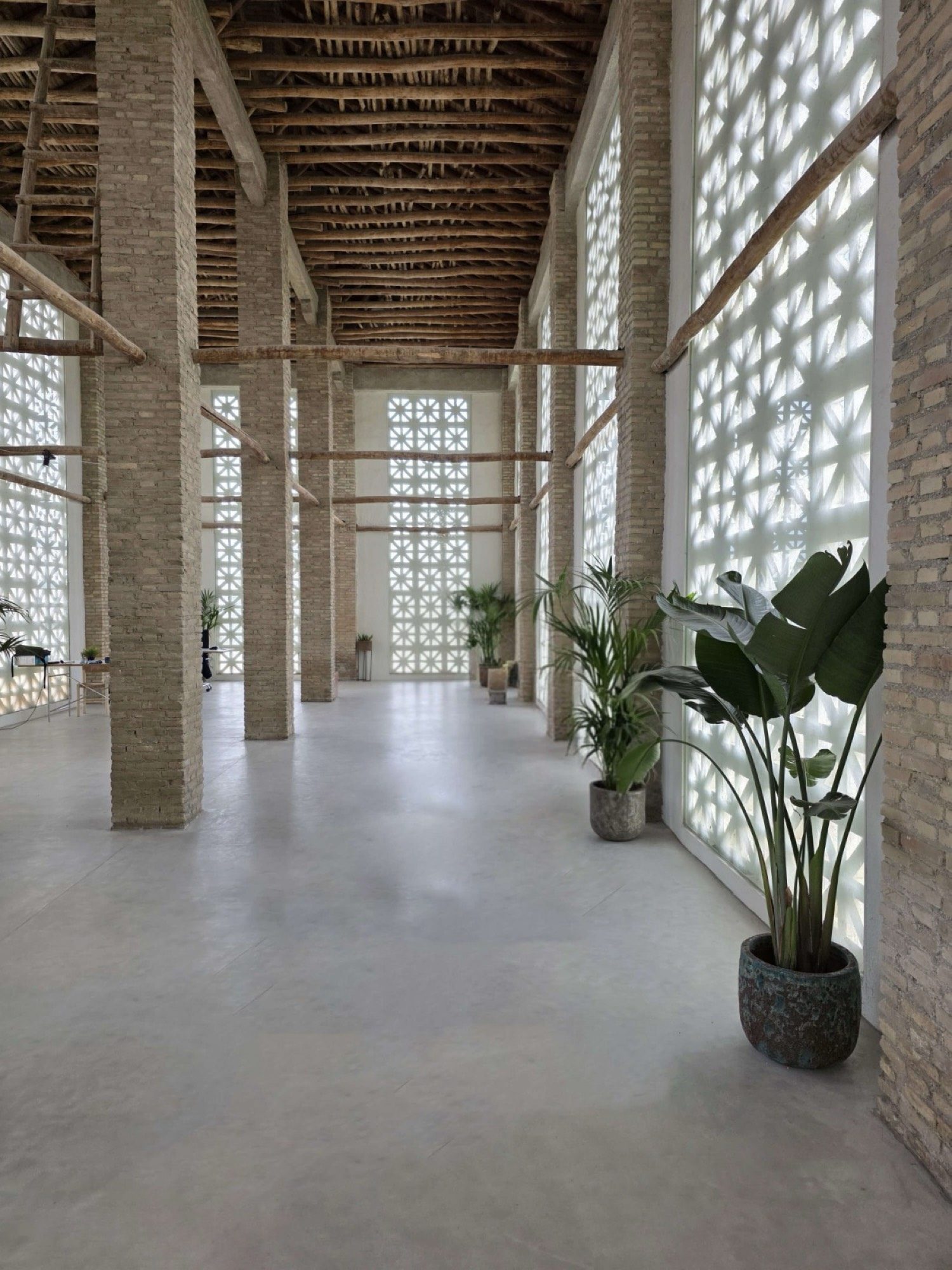 Gran espacio interior con celosías, vigas de madera y luz filtrada