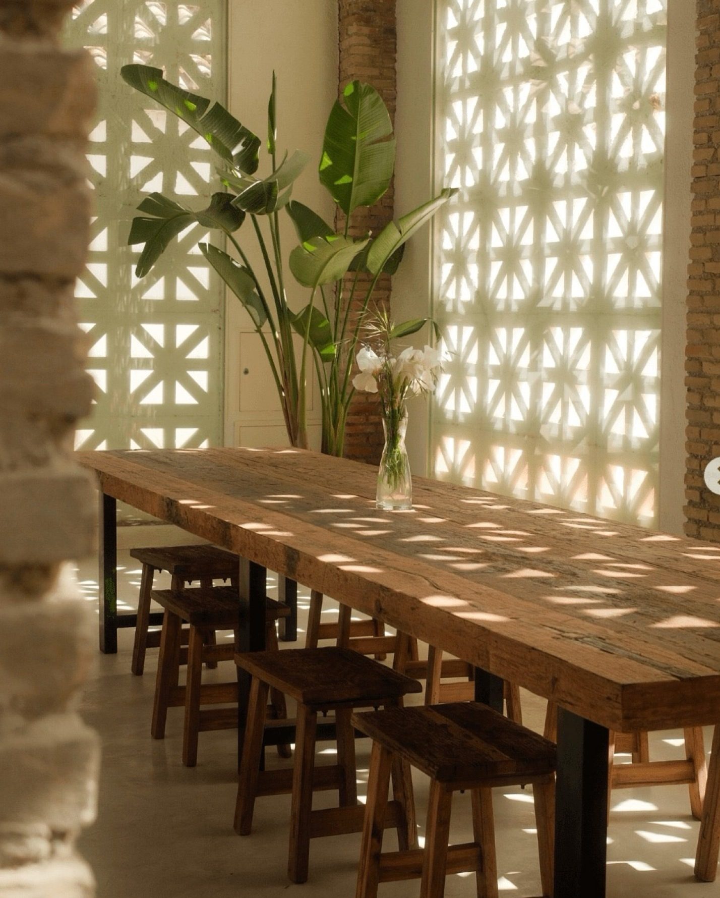 Interior del Cortijo de la Seda: mesa de madera, celosías y luz natural
