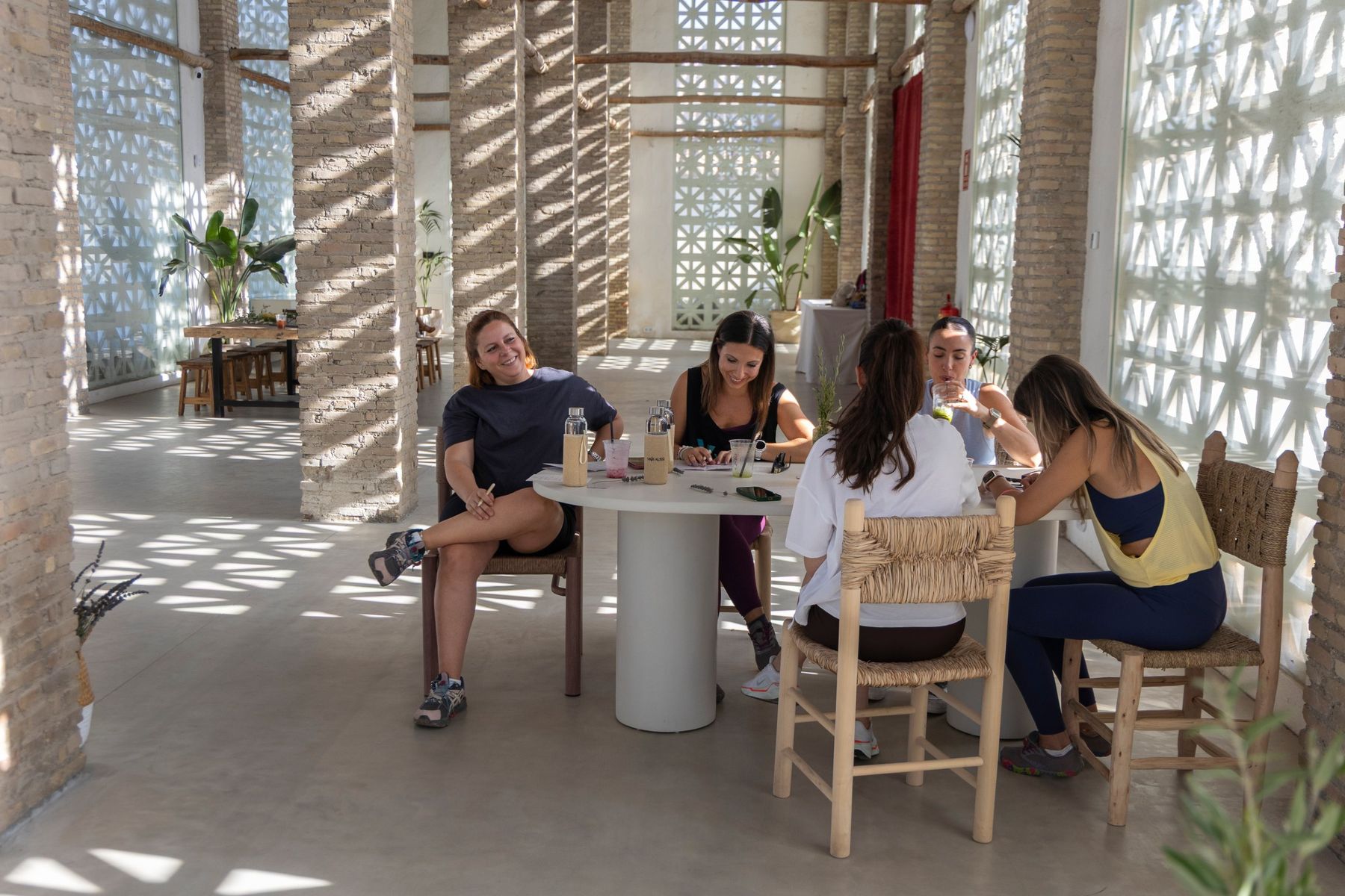 Mujeres sonriendo y conversando alrededor de una mesa en la primera experiencia MOI AUSSI